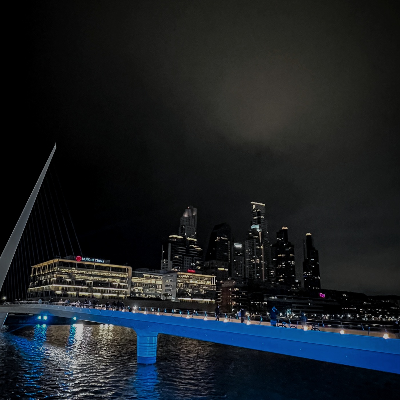 Ponte iluminada e cidade à noite